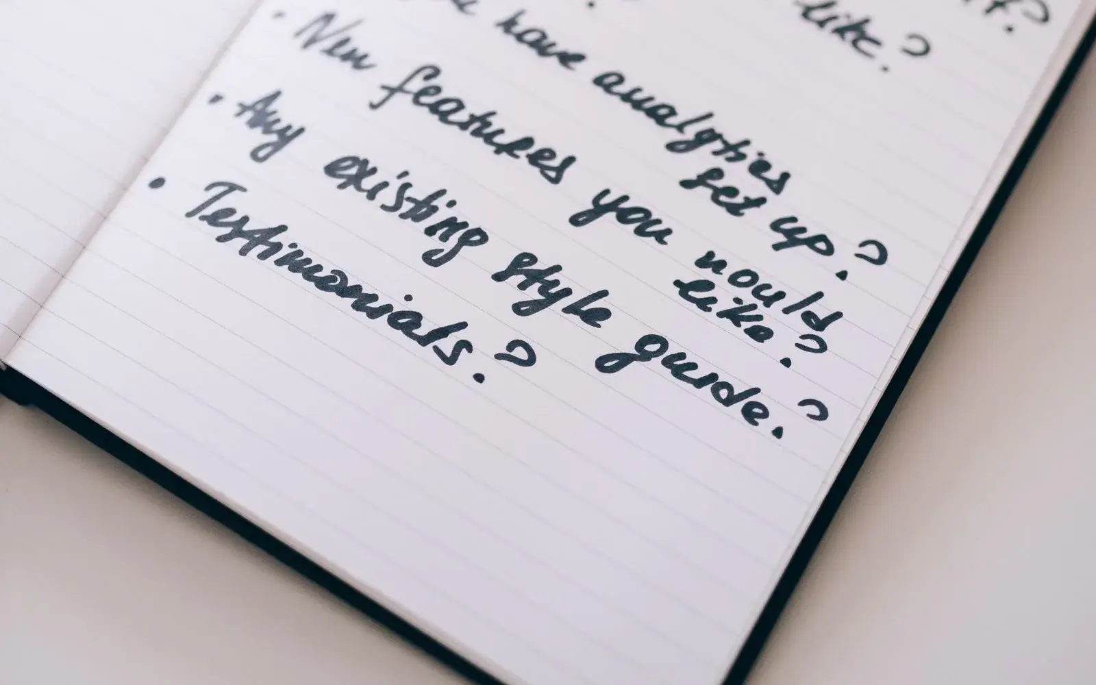 Open notebook with handwritten planning notes beside a laptop